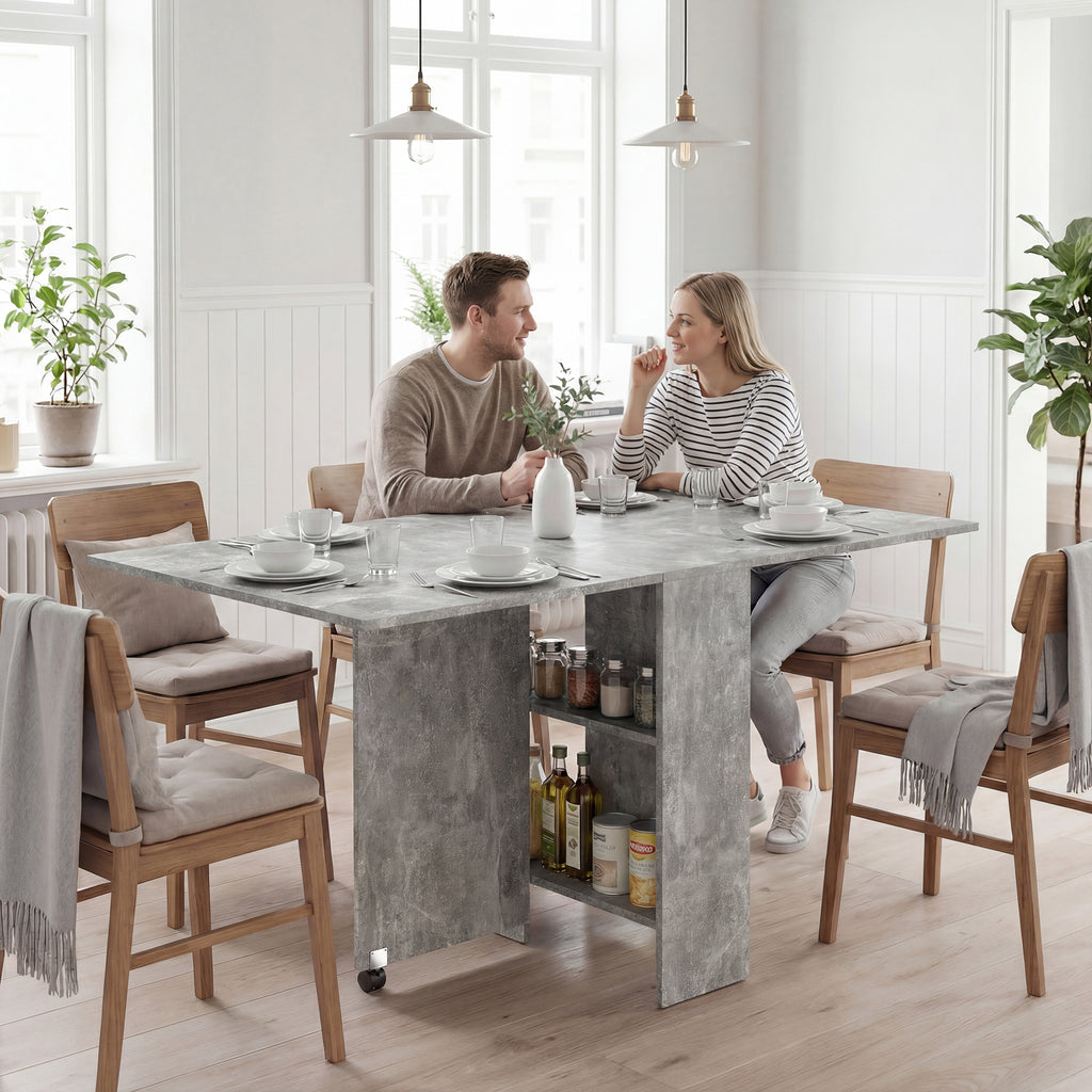 Tavolo pieghevole grigio aperto con due ripiani centrali e ruote, esempio di utilizzo in sala da pranzo